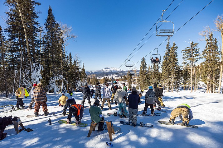Contestants at the “The Site” snowboarding and ski competition wait to do a run down Sunset Terrain Park on Jan. 28, 2023. Collective Supply Co., a clothing brand geared toward the Flagstaff snowboarding community, co-hosted the competition with the park. (Drake Presto/Cronkite News)