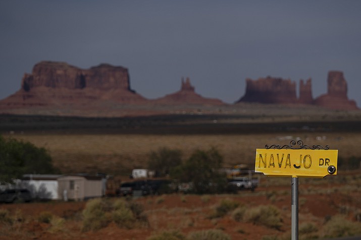A sign marks Navajo Drive, as Sentinel Mesa, homes and other structures in Oljato-Monument Valley, Utah, on the Navajo Reservation, stand in the distance, on April 30, 2020. The U.S. Supreme Court will soon decide a critical water rights case in the water-scarce Southwest. The high court will hold oral arguments Monday, March 20, 2023, in a case with critical implications for how water from the drought-stricken Colorado River is shared and the extent of the U.S. government’s obligations to Native American tribes. (Carolyn Kaster/AP, File)