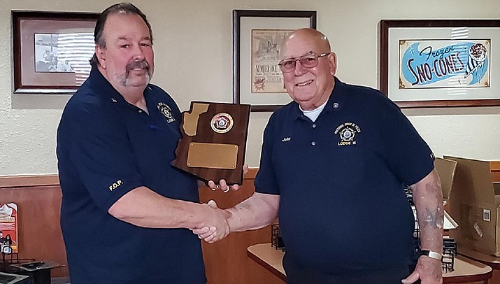 Ray Cullison, left, received this plaque of appreciation from Fraternal Order of Police President John Slaughter for his past service as president of FOP Mohave Lodge 16. (Courtesy photo)