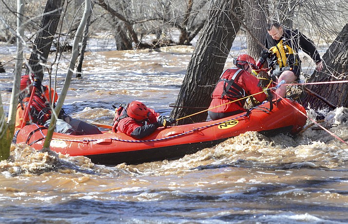 A man stuck in a tree is rescued by swift water teams from Copper Canyon Fire and Medical District, and the Verde Valley Fire District on Wednesday, March 22, 2023, in Camp Verde, Ariz. Several water rescues were reported across central and northern Arizona on Wednesday. (Vyto Starinskas/The Verde Indepemdent via AP)