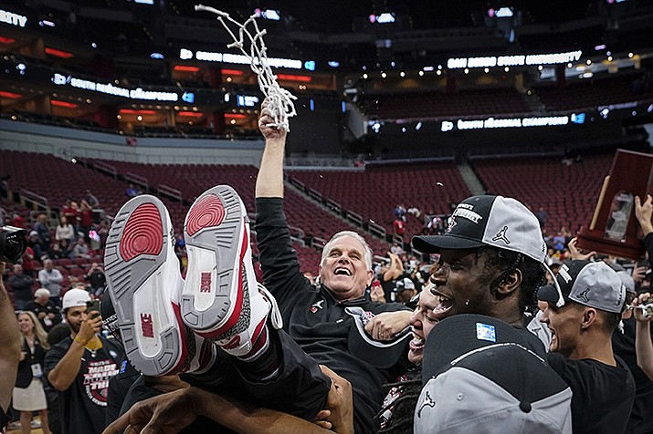 San Diego State head coach Brian Dutcher holds the remains of the net and is hoisted in the air by his team after a Elite 8 college basketball game between Creighton and San Diego State in the South Regional of the NCAA Tournament, Sunday, March 26, 2023, in Louisville, Ky. San Diego State won 57-56. (Mike Stewart/AP)