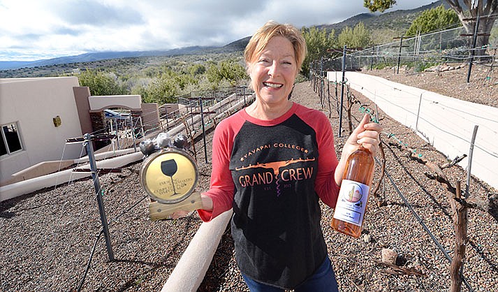 Christine Eckels poses in her backyard vineyard above Cottonwood with last year’s Emerging Wine Symposium Best of Show award and a bottle of her vineyard’s wine, Morning Wood Vineyard. (VVN/Vyto Starinskas)