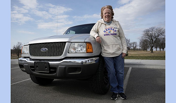 Carol Rice stands with her recently-purchased 2003 Ford Ranger Wednesday, March 15, 2023, in Shawnee, Kansas. Rice's timing to buy the truck was ideal, taking advantage of a recent dip in used car prices which now appear to be heading back up. (AP Photo/Charlie Riedel)