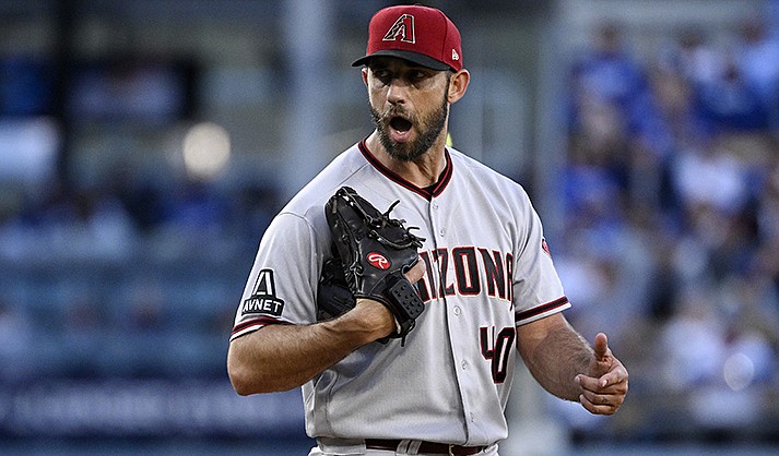 Arizona Diamondbacks starting pitcher Madison Bumgarner has words with home plate umpire John Tumpane after Trumpane appears to ask him to speed things up during the first inning of a baseball game Saturday, April 1, 2023, in Los Angeles. (AP Photo/Mark J. Terrill)