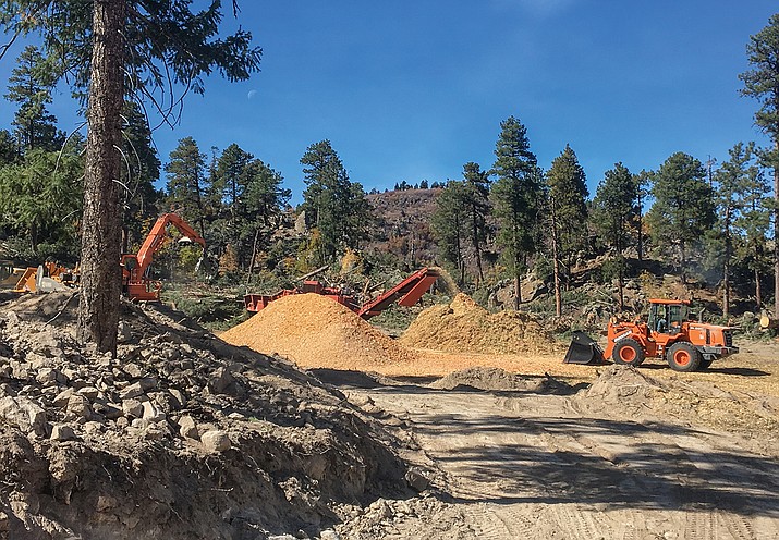 Material cut from Bill Williams Mountain is flown down by a helicopter to an area where it is chipped and then transported by truck off of the mountain as part of a steep slope forest thinning project in 2019. (Photo/Kaibab National Forest)