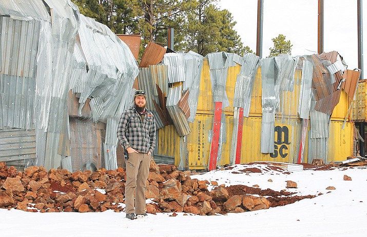 Bearizona has repurposed over 200,000 tons of scrap metal and steel in the walls of enclosures. Animal program manager Kyle Alexander stands next to large shipping containers, scrap metal and vehicles which are the base of the new grizzly habitat. (Wendy Howell/WGCN)