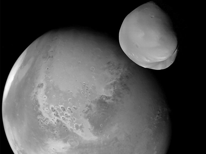 This image provided by the UAE Space Agency shows the planet Mars and its moon, Deimos, in the foreground. The United Arab Emirates’ Amal spacecraft - Arabic for Hope - flew within 62 miles of Deimos in March 2023. (UAE Space Agency via AP)