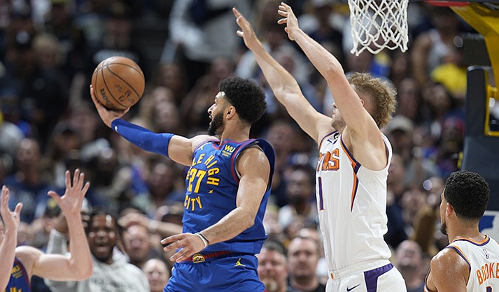 Denver Nuggets guard Jamal Murray, left, goes up for a basket as Phoenix Suns center Jock Landale defends in the second half of Game 1 of an NBA second-round basketball series Saturday, April 29, 2023, in Denver. (AP Photo/David Zalubowski)