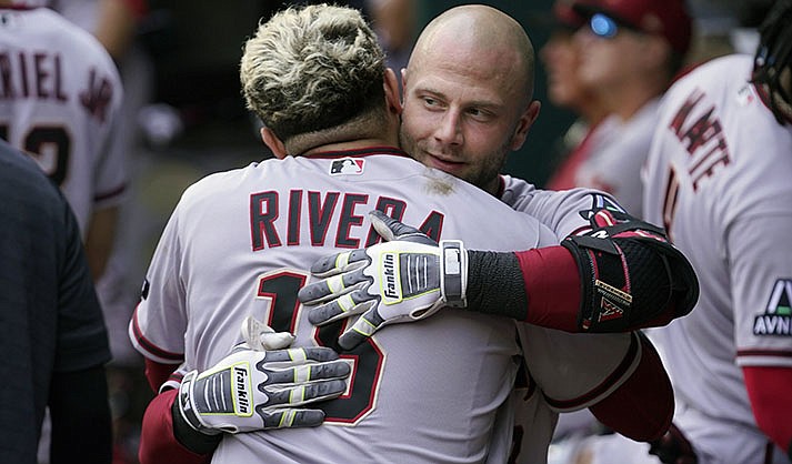 Arizona Diamondbacks' Christian Walker, right, gets a hug from teammate Emmanuel Rivera (15) after Walker hit a solo home run during the fifth inning of a baseball game against the Texas Rangers in Arlington, Texas, Wednesday, May 3, 2023. (AP Photo/LM Otero)
