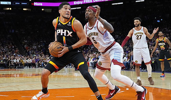 Phoenix Suns guard Devin Booker (1) looks to shoot as Denver Nuggets guard Kentavious Caldwell-Pope (5) defends during the first half of Game 3 of an NBA basketball Western Conference semifinal game, Friday, May 5, 2023, in Phoenix. (AP Photo/Matt York)