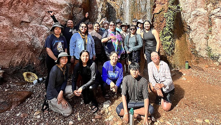 2022 RIISE participants gather around a waterfall in the Grand Canyon. (Amber Benally/Grand Canyon trust)