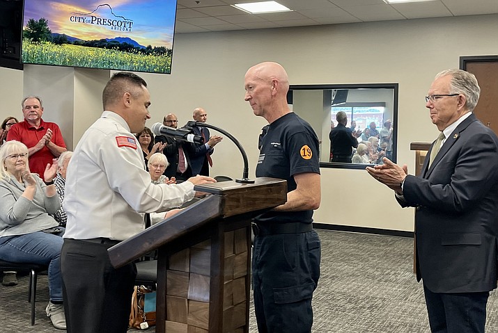 During a Prescott City Council meeting on Tuesday, May 23, 2023, Prescott Firefighter/Paramedic Jeff Jones, center, was honored as the Prescott Fire Department’s paramedic of the year for 2023. Prescott Fire Chief Holger Durre, left, presented the award to Jones, as Prescott Mayor Phil Goode, right, looked on. (Cindy Barks/Courier)