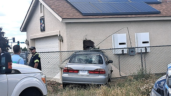 CAFMA firefighters tend to a car that crashed into a home on Robert Road Friday afternoon. (Debra Winters/Courier)