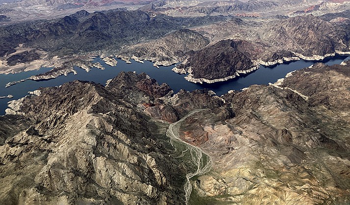 In this aerial photo, a bathtub ring of light minerals show the high water mark on the shore of Lake Mead along the border of Nevada and Arizona, Monday, March 6, 2023, near Boulder City, Nevada. The federal government is expected to make an announcement on Tuesday, Aug. 15, 2023, about the health of the Colorado River and water cuts in 2024. (AP Photo/John Locher, File)