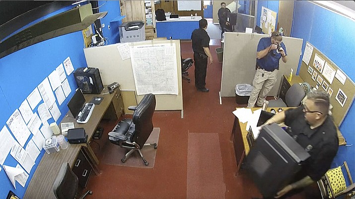 This surveillance video shows Marion Police Department confiscating computers and cellphones from the publisher and staff of the Marion County Record Aug. 11 in Marion, Kan. The small newspaper and the police department in Kansas are at the center of a dispute over freedom of speech that is being watched around the country after police raided the office of the local newspaper and the home of its owner and publisher. (Marion County Record via AP)