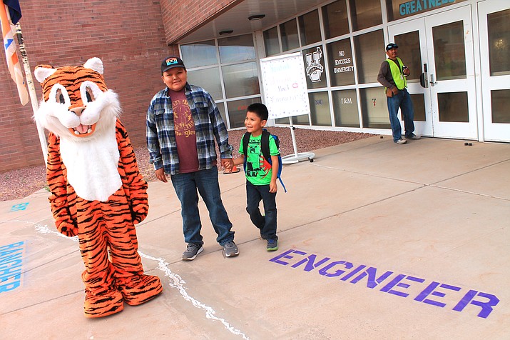 Theresa the Tiger and Deon Chee greet Colten and Aiden Begaye on their first day of fifth grade and kindergarten at Leupp Elementary School on Aug. 9.