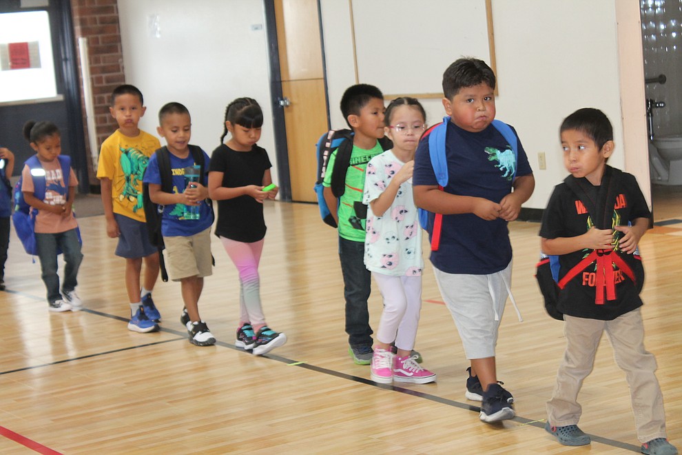 Kindergarten students "catch a bubble" as they walk to their new classroom