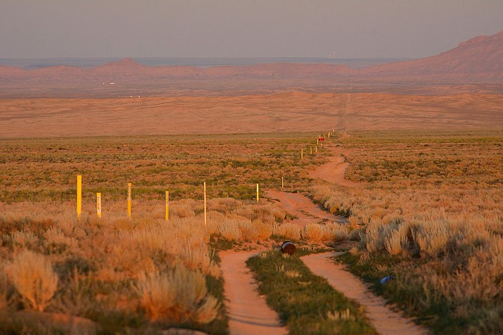 Dusk falls on the existing Southern Trails natural gas pipeline owned by the Navajo Nation as it passes through empty land west of Shiprock, New Mexico. Locals say someone showed up and put in the yellow markers a few months earlier. (Photo/Jerry Redfern/Capital and Main)