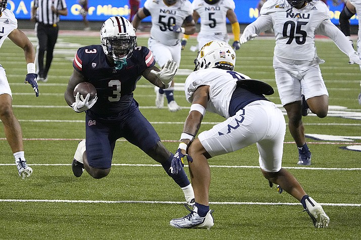 Arizona running back Jonah Coleman (3) looks to fend off Northern Arizona defensive back Shawn Dourseau (0) during the first half of an NCAA college football game Saturday, Sept. 2, 2023, in Tucson, Ariz. (Rick Scuteri/AP)