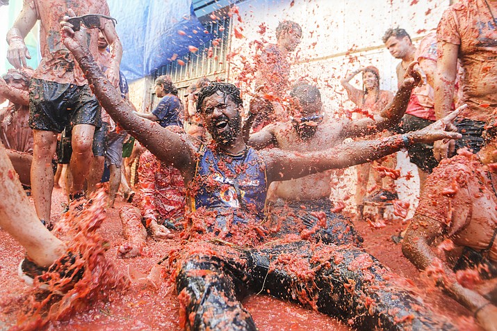 Revellers throw tomatoes at each other during the annual “Tomatina”, tomato fight fiesta in the village of Bunol near Valencia, Spain, Wednesday, Aug. 31, 2022. The tomato fight took place once again following a two-year suspension owing to the coronavirus pandemic. (Alberto Saiz/AP)