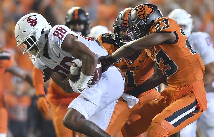 Oregon State's Ryan Cooper Jr. (23) attempts to strip the ball from Washington State's De'Zhaun Stribling (88) while Oregon State's Omar Speights (1) assists on the tackle during the first half of an NCAA college football game Saturday, Oct. 15, 2022, in Corvallis, Ore. Oregon State and Washington State are the last remaining members of the Pac-12 after this season and they have been fielding calls from the likes of the Mountain West and American Athletic conferences eager to discuss options. (Mark Ylen/AP, File)