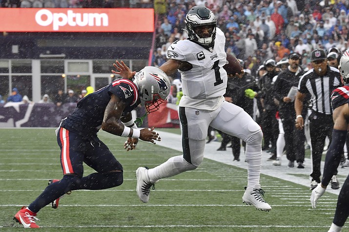 Philadelphia Eagles quarterback Jalen Hurts (1) is pursued by New England Patriots cornerback Jalen Mills, left, in the first half of a game, Sunday, Sept. 10, 2023, in Foxborough, Mass. (Mark Stockwell/AP)
