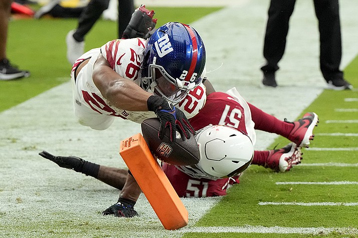 New York Giants running back Saquon Barkley (26) dives into the end zone for a touchdown as Arizona Cardinals linebacker Krys Barnes (51) defends during the second half of an NFL football game, Sunday, Sept. 17, 2023, in Glendale. (Rick Scuteri/AP)