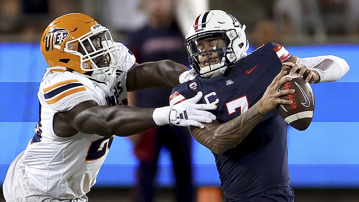 Arizona quarterback Jayden de Laura (7) manages to get away from a UTEP defender during an NCAA college football game between UTEP and Arizona on Saturday, Sept. 16, 2023, in Tucson, Ariz. (Kelly Presnell/Arizona Daily Star via AP)