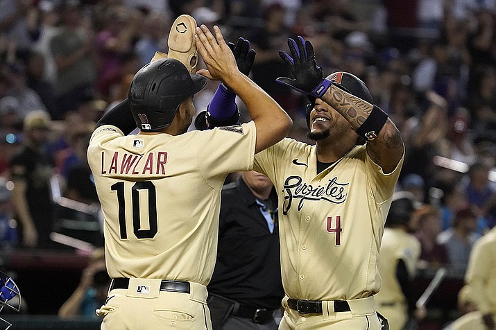 Arizona Diamondbacks' Ketel Marte (4) is greeted at home plate by Jordan Lawlar (10) after hitting a two-run home run against the Chicago Cubs during the sixth inning Sunday, Sept. 17, 2023, in Phoenix. (Darryl Webb/AP)