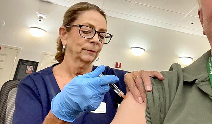 Barb Vaughn, RN, from Occupational Health Service, gives flu and COVID vaccine shots during a clinic for Sedona employees at the City Council Chambers on Wednesday, Sept. 27, 2023. People could get a flu shot in one arm and a COVID shot to fight the new variant in the other arm. (VVN/Vyto Starinskas)