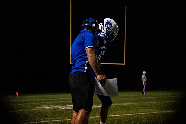 Chino Valley football coach Ricky Herrera talks to a player on the sideline in a game during the 2023 season. (Chris Ortiz/Courier)