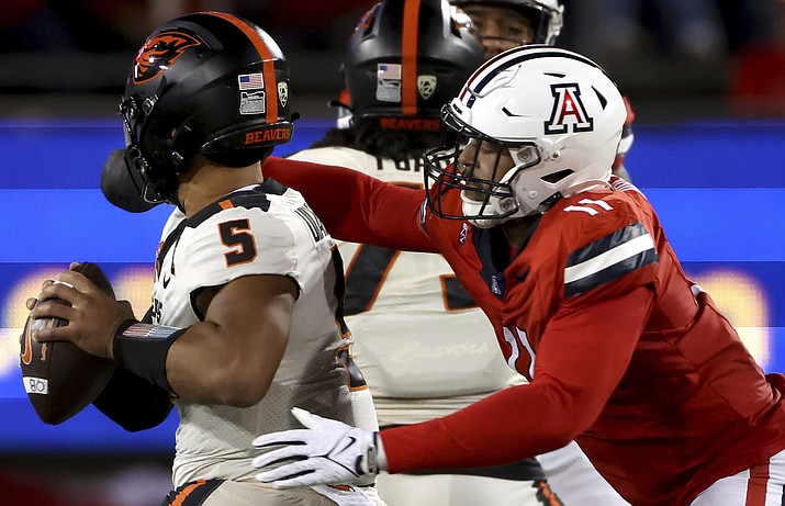 Arizona linebacker Taylor Upshaw (11) sacks Oregon State quarterback DJ Uiagalelei (5) during the second quarter of an NCAA college football game Saturday, Oct. 28, 2023, in Tucson, Ariz. (Kelly Presnell/Arizona Daily Star via AP)