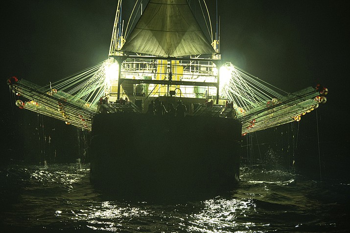 In this July 2021 photo provided by Sea Shepherd, the Chang Tai 802, a Chinese-flagged ship, fishes for squid at night on the high seas off the west coast of South America. Hazardous work conditions sometimes akin to slavery have been detected on nearly 500 industrial fishing vessels around the world, including this one, but identifying those responsible for abuses at sea is hampered by a lack of transparency and regulatory oversight, according to research by the Financial Transparency Coalition released on Wednesday, Nov. 15, 2023. (Isaac Haslam/Sea Shepherd via AP, File)