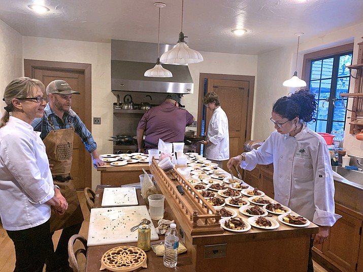 Chefs Brett Vibber and Jaren Bates supervise as Flagstaff High School’s culinary arts team helps with plating small bites of duck with fall squash for the “More than a Meal” tasting at Museum of Northern Arizona’s Colton House Nov. 5. (Photo/Claudine Taillac)