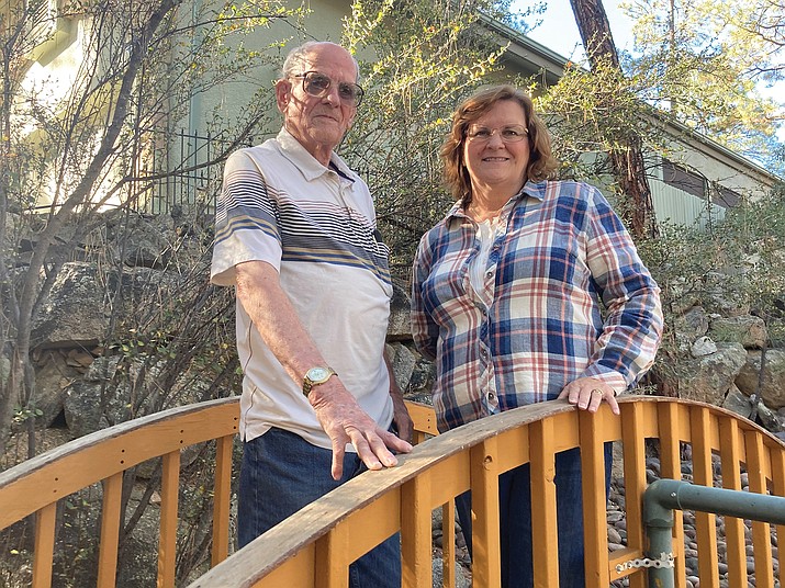 United States Navy career veteran of the Korean and Vietnam wars, Phillip Gresham, 90, a Hidden Valley Ranch resident since 1990, poses with his daughter, Debbie Hillman, on the footbridge Gresham built in his front yard. (Nanci Hutson/Courier)