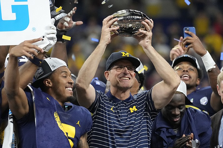 Michigan head coach Jim Harbaugh holds the trophy after defeating Purdue in the Big Ten championship, Sunday, Dec. 4, 2022, in Indianapolis. (AJ Mast/AP-File)
