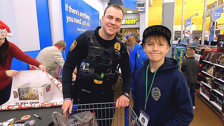 Ryan Cedro, Prescott PD, helps Sam wrap his presents at Shop with a Cop on Saturday, Dec. 11, 2021. This year’s event is scheduled for Saturday, Dec. 9, 2023. (Jesse Bertel/Courier file photo.)