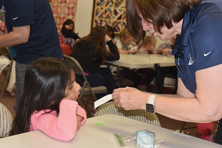 Julie Mason, a regional outreach officer from the U.S. Patent/Trademark office, helps Sofia Rivas, 4, build a pocket flashlight at the Chino Valley Public Library on Tuesday, Nov. 28, 2023. (Jesse Bertel/Review)