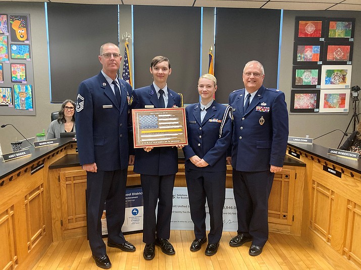 Prescott High School Air Force JROTC instructors retired United States Air Force Senior Master Sgt. Erik Appeldoorn (left) and retired United States Air Force Lt. Col. Bill DeKemper (far right), the department chairman, with AFJROTC Senior Commander Bruce Reynolds and Junior Vice Commander Hannah Block as they present their winning recognition plaque at the Prescott Unified School District Governing Board meeting on Tuesday, Dec. 5.