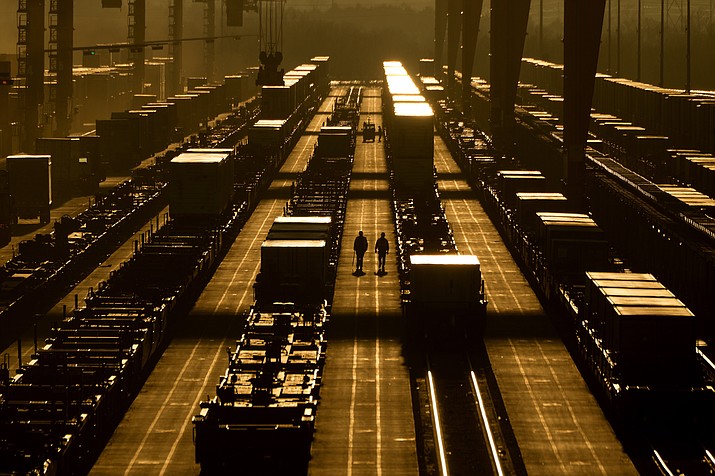 Workers walk among shipping containers at a BNSF intermodal terminal, Wednesday, Jan. 3, 2024, in Edgerton, Kan. (Charlie Riedel/AP)