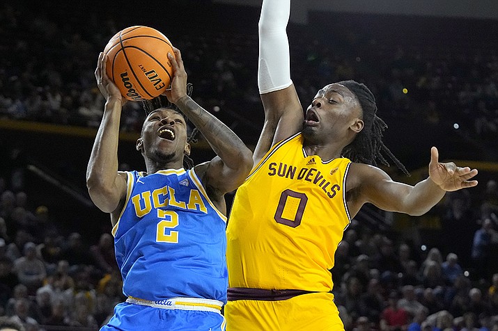 UCLA guard Dylan Andrews (2) drives past Arizona State guard Kamari Lands (0) during the first half of an NCAA college basketball game Wednesday, Jan. 17, 2024, in Tempe, Ariz. (Ross D. Franklin/AP)