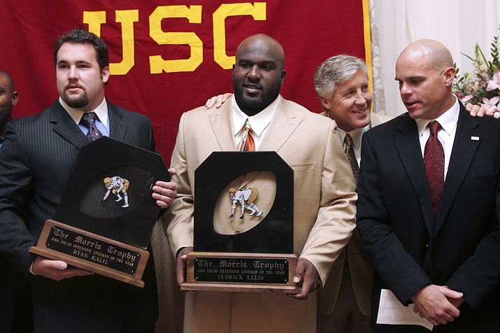 Southern California coach Pete Carroll chats with defensive coordinator Nick Holt, right, during a photo session with Morris Trophy winners, center Ryan Kalil, left, and nose tackle Sedrick Ellis, both of USC, at the Washington Athletic Club in Seattle, Jan. 18, 2007. The Morris Trophy was never a name-brand award handed out following the college football season, in part because it honored offensive and defensive linemen, players who sometimes don't get the recognition they deserve. But it was special on the West Coast and special to the Pac-10 or Pac-12. Every year since 1980 it's been awarded, and perhaps most notably was voted on by the players themselves. Coaches and media had no influence in the final decision. (Joe Nicholson/AP-File)
