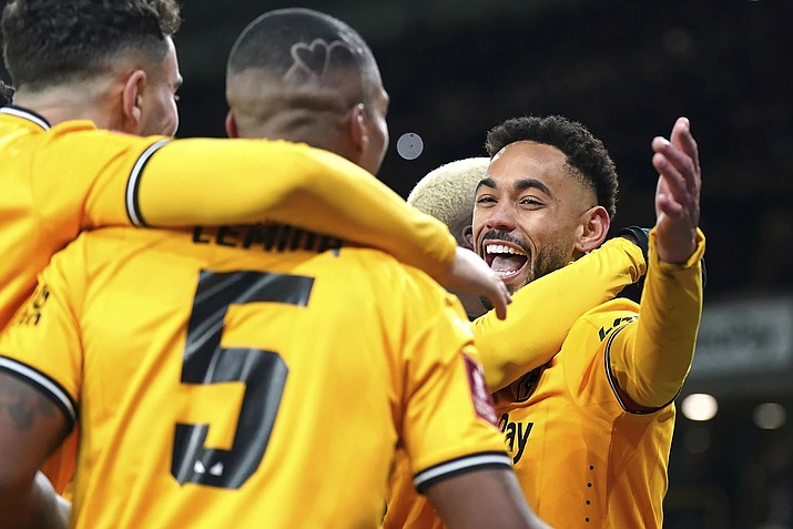 Wolverhamption Wanderers' Matheus Cunha, Right, celebrates scoring their side's third goal of the game from the penalty spot with teammates in extra time during the English FA Cup third round replay soccer march between Wolverhamption Wanderers and Brentford at the Molineux Stadium.