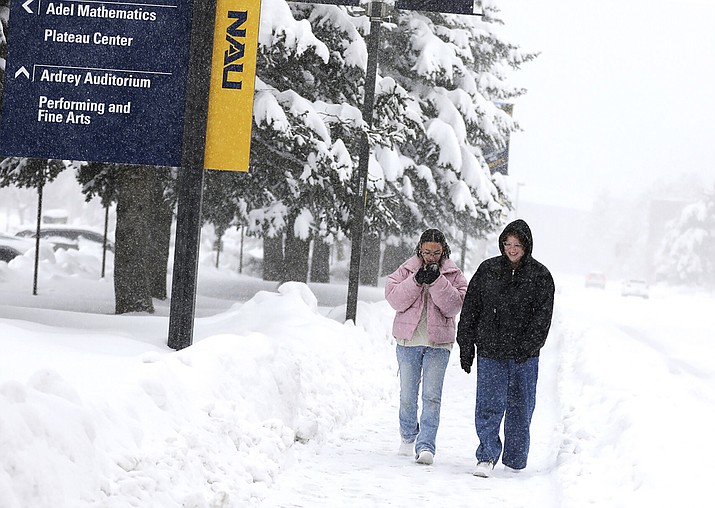 Students Destyne Barbosa, left, and Maddie Eckhoff walk through a snowstorm on the Northern Arizona University campus in Flagstaff, Ariz., Thursday, Feb. 8, 2024, after classes were canceled for the day. (Hattie Loper/Arizona Daily Sun via AP)