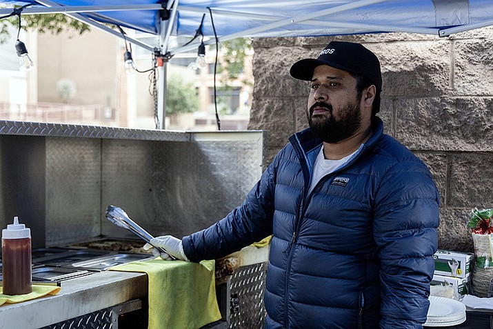 Sergio Vargas, owner of Player Breakfast Club, stands on the corner of Adams and Second streets in downtown Phoenix at his taco stand on Jan. 24. (Photo by Sam Ballesteros/Cronkite News)